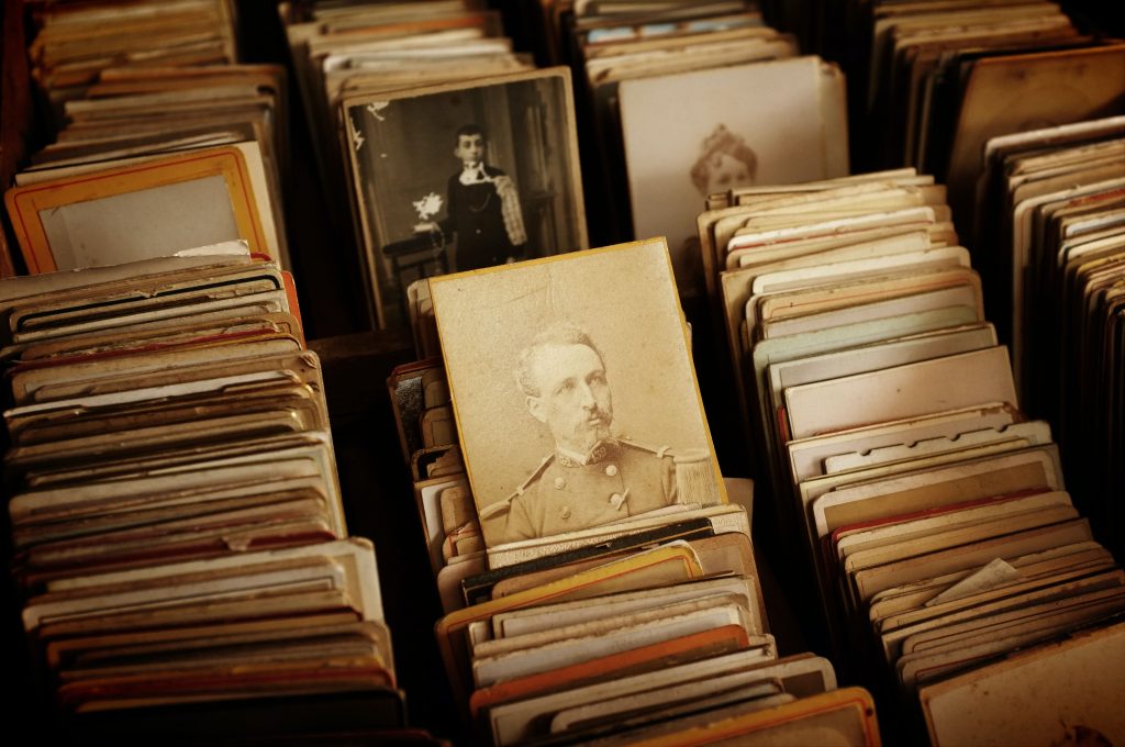 Old black-and-white photographs stacked together in a pile